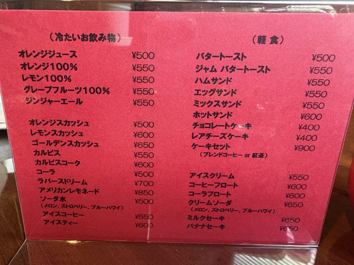 網走「珈琲屋 デリカップ」のメニュー表。冷たいお飲み物（ジュースやフロート類）と、バタートーストやサンドイッチ、ホットサンド、ケーキセットなどの軽食メニューが掲載されている。
The food and cold drink menu at "Coffee-ya Delicup" in Abashiri, listing options like sandwiches, toast, cakes, fruit juices, and cream sodas.