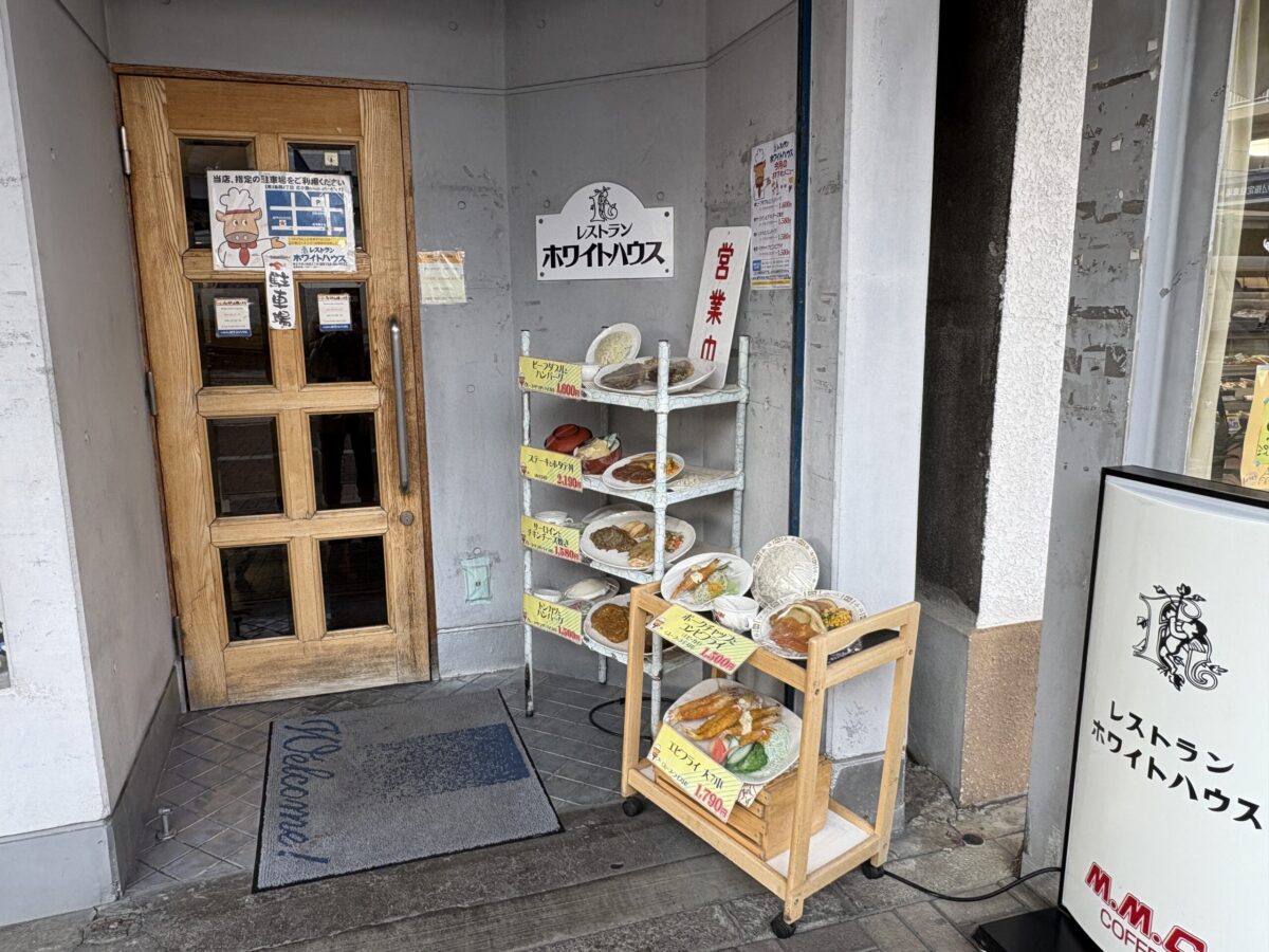 「レストラン ホワイトハウス」の店内入り口。木目調の落ち着いた内装で、レトロな雰囲気の照明や棚があり、昔ながらの洋食レストランの趣を感じさせる空間。
The entrance area inside "Restaurant White House" in Abashiri, featuring a warm, retro-style interior with wooden furnishings and classic lighting.