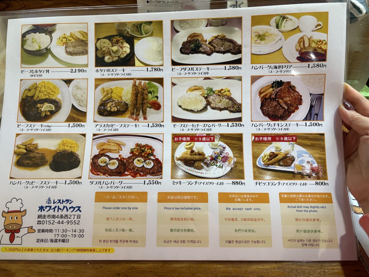 網走「レストラン ホワイトハウス」の写真付きメインメニュー。ビーフとホタテ丼、ハンバーグと海老ドリアといった独自のコンボ料理や、お子様用のミッキーランチなどが、日本語・英語・中国語・韓国語の案内と共に掲載されている。
Illustrated main menu of "Restaurant White House" in Abashiri, showing unique combos like beef and scallop bowls, and shrimp doria with hamburger, with multilingual descriptions.