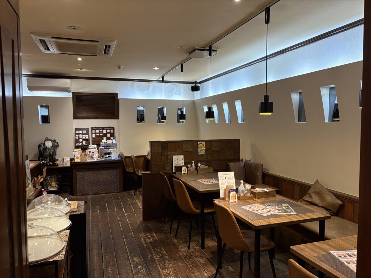 網走の「UROKO」店内の窓際にあるテーブル席。木の質感を生かしたナチュラルなテーブルと黒い椅子が並び、大きな窓からは明るい自然光が差し込んでいる。モダンなペンダントライトが吊り下げられた、開放感のある洗練された空間。
Window-side table seating inside "UROKO" in Abashiri. Features natural wooden tables and black chairs with bright natural light coming through large windows. The space is stylish and airy, decorated with modern pendant lights.