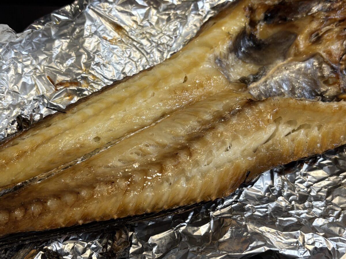 網走産の希少魚「八角」をこんがりと焼き上げた様子。独特の角ばった皮が香ばしく焼け、白い身から脂が溢れ出している、網走ならではの冬の味覚。
Golden-brown grilled Hakkaku (Sailfin poacher) fish from Abashiri. The image captures the crispy skin and juicy, fatty white meat of this local Hokkaido delicacy.