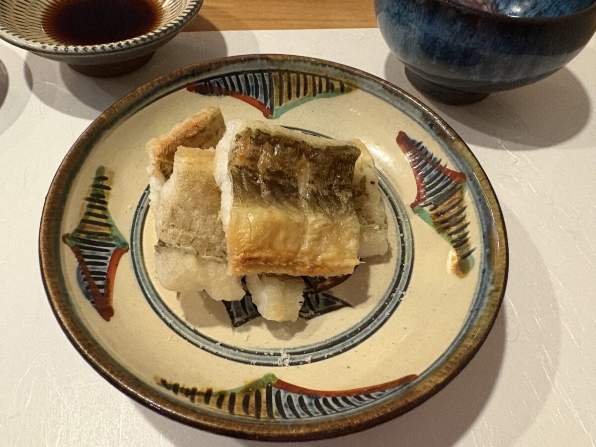 網走「鮨 やまし田」で提供された「あなごの白焼き」。丁寧に火入れされ、皮目は香ばしく身はふっくらと焼き上げられた大ぶりの穴子が、趣のある器に上品に盛り付けられた一皿。
Shirayaki (salt-grilled) conger eel served at Sushi Yamashita in Abashiri. The image shows the beautifully grilled, plump eel with a crispy skin, presented on a traditional Japanese plate, highlighting the chef's expertise.