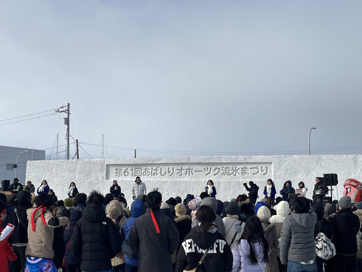 網走オホーツク流氷まつりの有名なイベント。雪のステージから熱狂的な観客に向かってホタテが撒かれている様子 A famous event at the Abashiri Okhotsk Drift Ice Festival where scallops are tossed from the snow stage to the excited crowd.