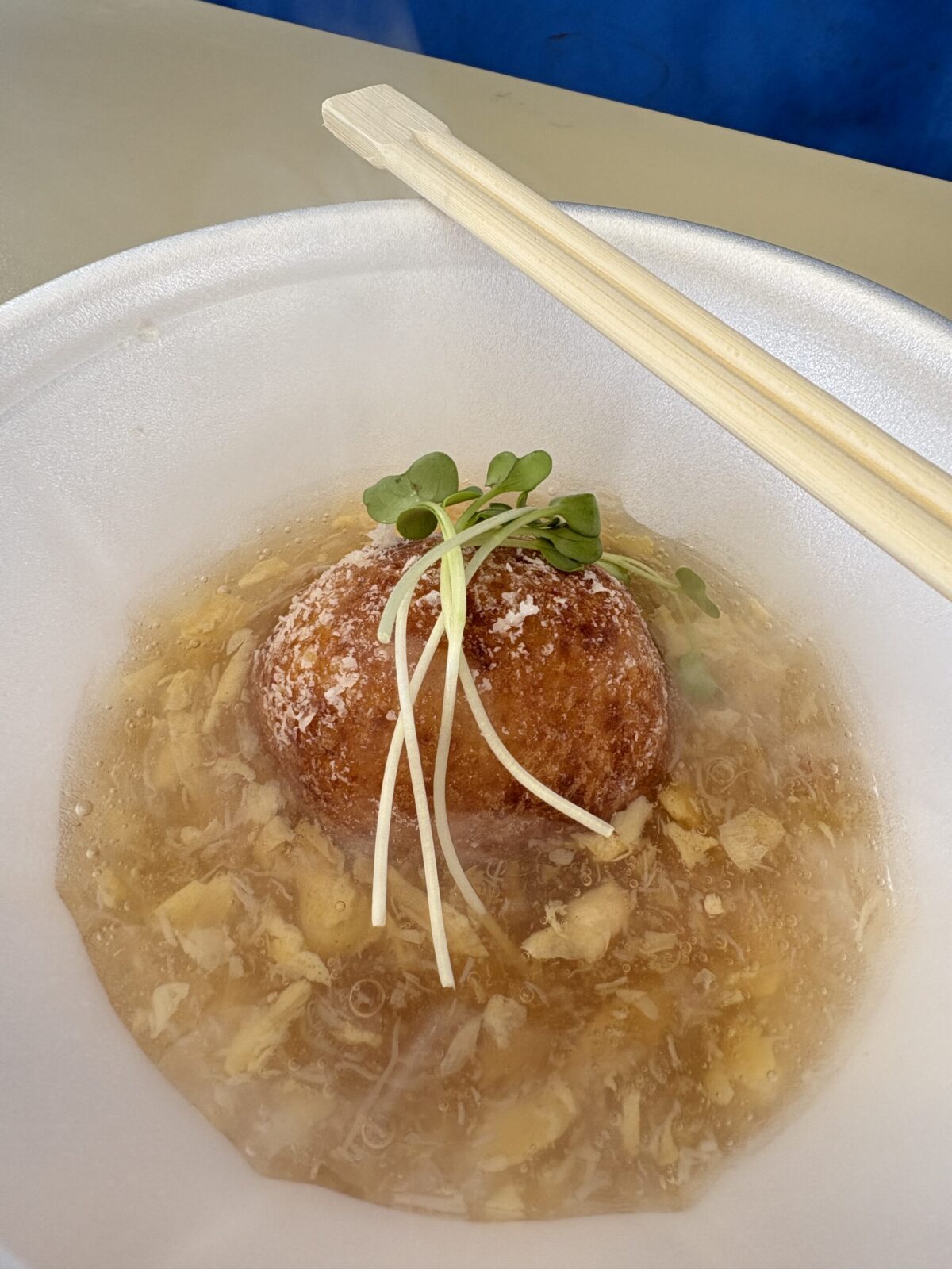 網走流氷まつりの出店で提供されている、熱々のあんがかかった名物料理「じゃがいもまんじゅう」
A famous local dish "Jagaimo Manju" (potato dumpling) served with thick savory starchy sauce at a food stall of the Abashiri Drift Ice Festival.