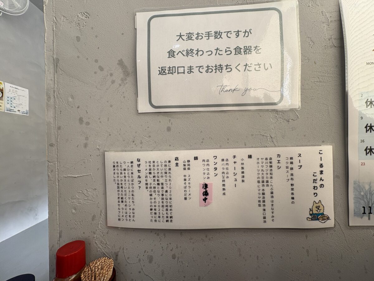 網走市の「らー麺 こーるまん」店内に掲示された「こーるまんのこだわり」。親鶏・豚・昆布・野菜のスープ、小林製麺の麺、24時間熟成のチャーシューなど、素材の詳細が記されている。また、東京から網走へ移住し開業した店主の経歴や、客とのコミュニケーションを大切にするためにセルフサービスを採用した理由「なぜセルフ？」という文章も記載されている。
A bulletin board titled "Callman's Commitment" inside "Ramen Callman" in Abashiri. It describes their ingredients: soup made from chicken, pork, and kelp; noodles from Kobayashi Seimen; and 24-hour aged chashu pork. The text also includes the owner's story of moving from Tokyo to Abashiri and the reason why the restaurant uses a self-service system to better engage with customers.