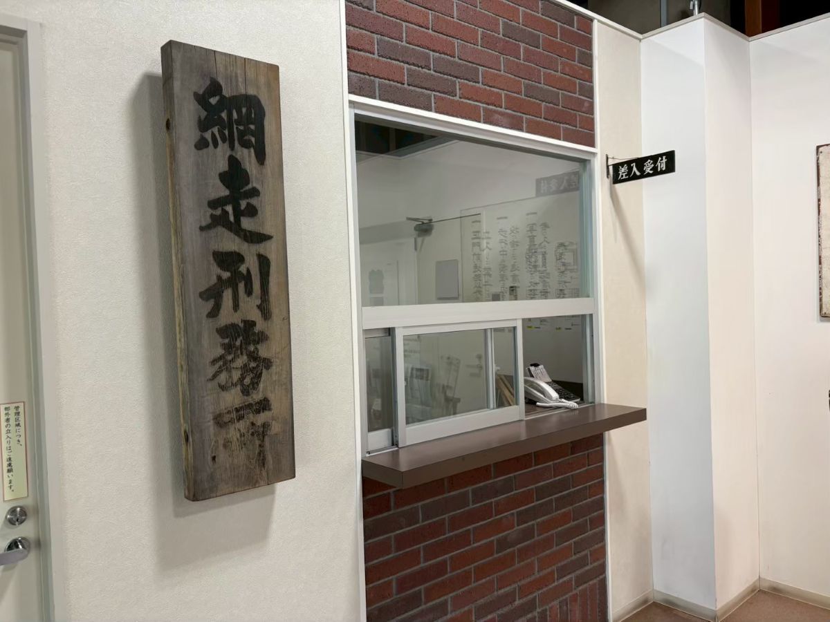 博物館 網走監獄の庁舎内にある差し入れ受付窓口。当時の面会や荷物の受け渡しを再現した歴史的展示
The reception window for inmate provisions and visits at the Abashiri Prison Museum, showing a historical reconstruction of prison life.