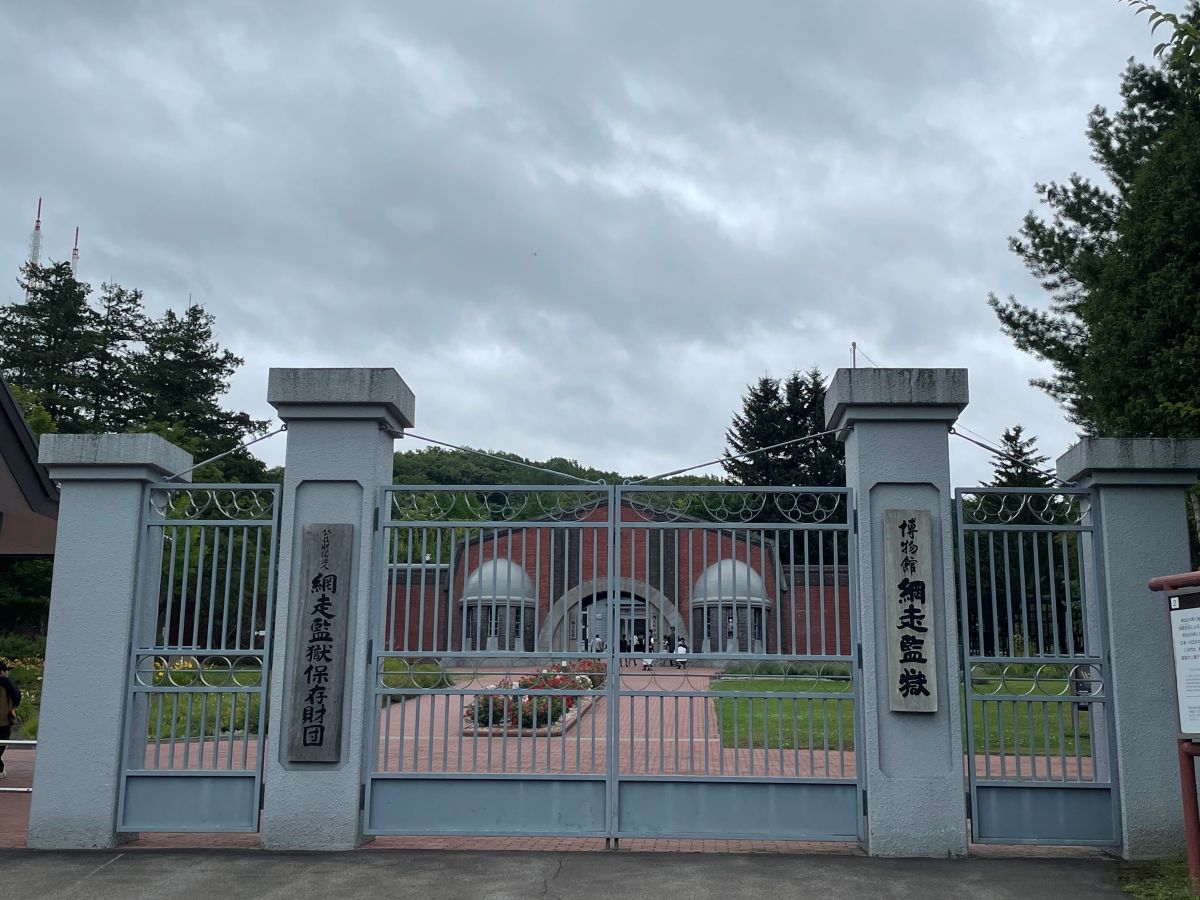博物館 網走監獄の正門。明治時代から続く赤煉瓦造りの重厚な門構えと青空
The historic red brick main gate of the Abashiri Prison Museum under a clear blue sky.