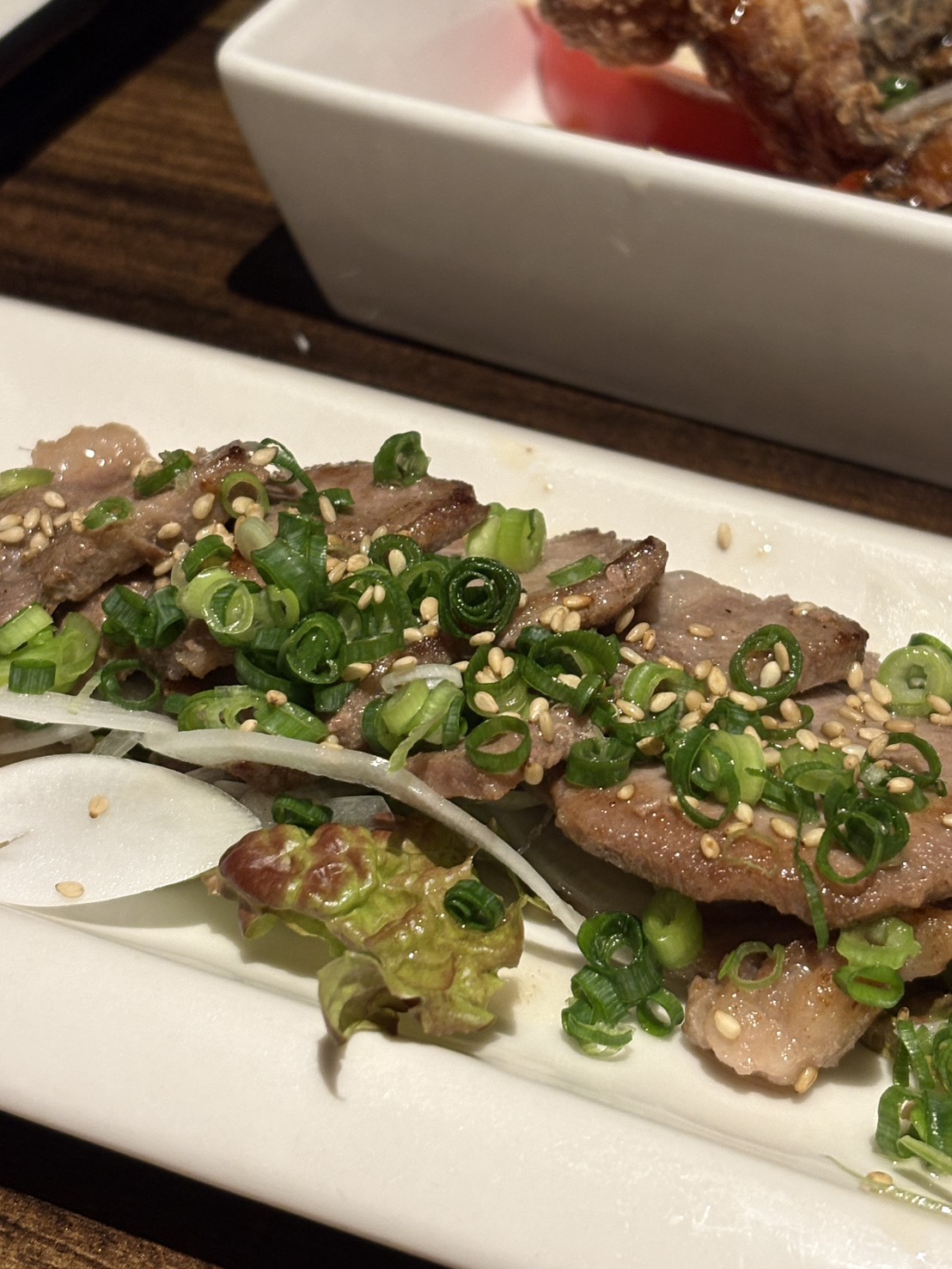 刻みネギとゴマがたっぷり乗った、網走のsawaのおすすめお肉料理
Savory grilled meat dish topped with green onions and sesame seeds at Sawa in Abashiri.
