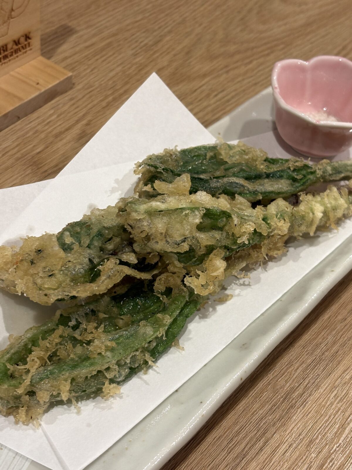 長皿に美しく盛り付けられた、サクサクの衣が美味しそうな行者ニンニクの天ぷら（ピンクの小鉢の塩添え）
Crispy and golden-brown wild alpine leek tempura (Gyoja-ninniku) served with a side of salt in a small pink dish at Nakano Sakaba.