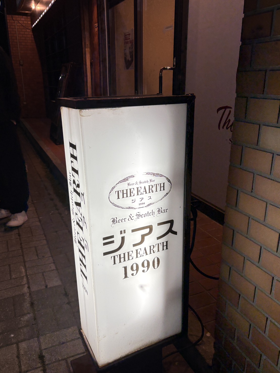 網走の繁華街に佇む、バー「ジアス（THE EARTH 1990）」の白い電飾看板 The illuminated outdoor signboard of BAR THE EARTH (established 1990) in Abashiri, Hokkaido