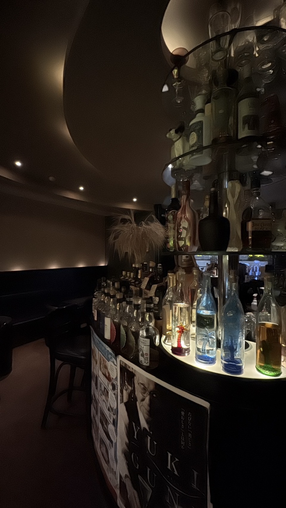 幻想的な光を放つ「BAR THE EARTH（ジアス）」店内の円柱状ボトルディスプレイ
Glowing circular bottle display tower inside BAR THE EARTH in Abashiri, Hokkaido.