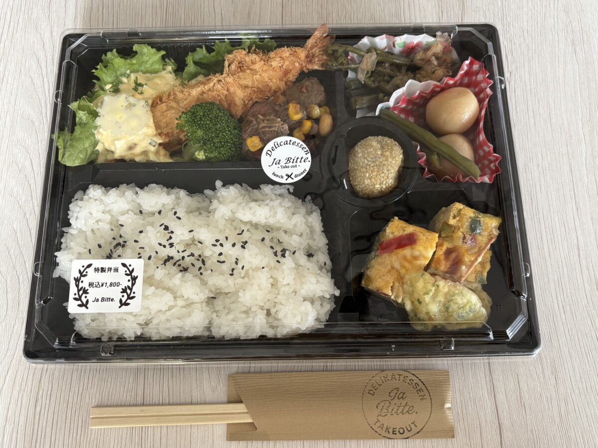 大きなエビフライやジューシーなお肉、地元の旬の山菜が入った「ja.bitte（ビッテ）」の贅沢な特製弁当
A luxurious and colorful "Tokusei Bento" lunch box filled with fried shrimp, meat, and local seasonal side dishes at ja.bitte.