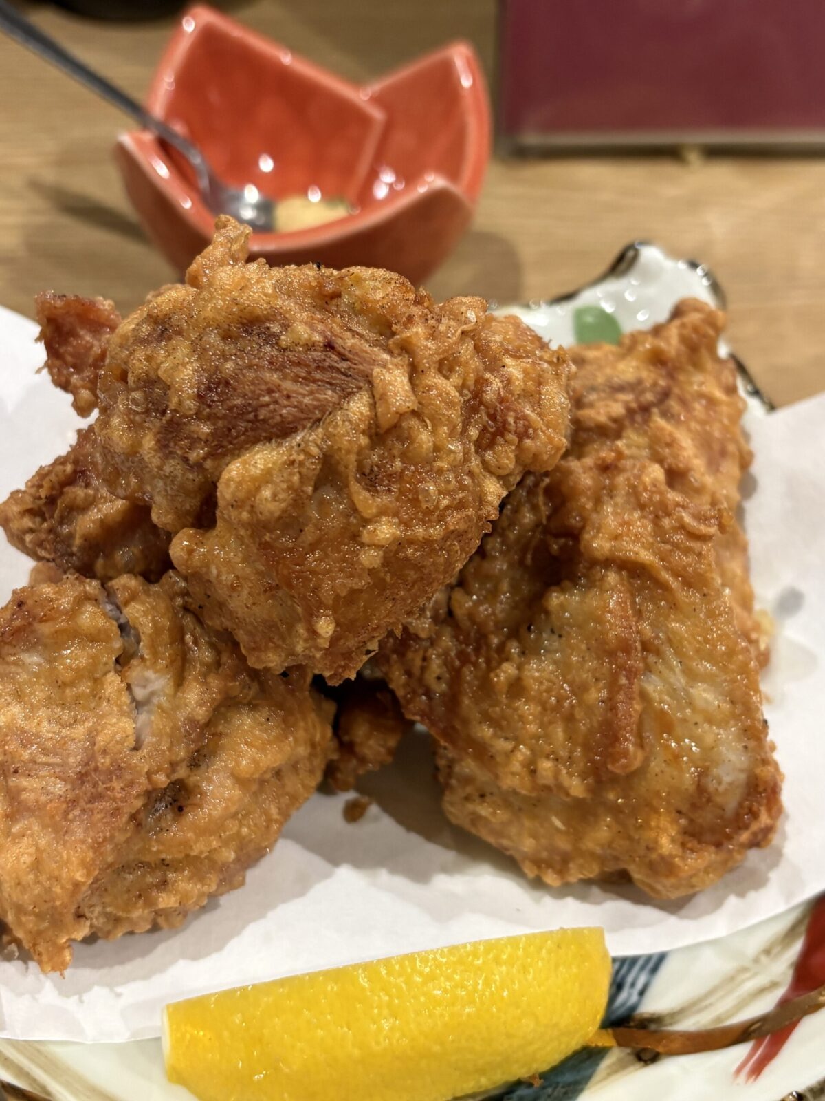 網走「なかの酒場」のカリッとジューシーに揚げられた、レモンが添えられた大ぶりの自家製ザンギ（鶏の唐揚げ）
Crispy and golden-brown Hokkaido-style deep-fried chicken (Zangi) served with a slice of lemon at Nakano Sakaba.