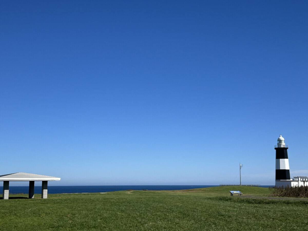 どこまでも続く青空と紺碧のオホーツク海、緑豊かな草原が広がる夏の能取岬の絶景
Breathtaking panoramic view of the deep blue Okhotsk Sea and green grasslands at Cape Notoro in summer