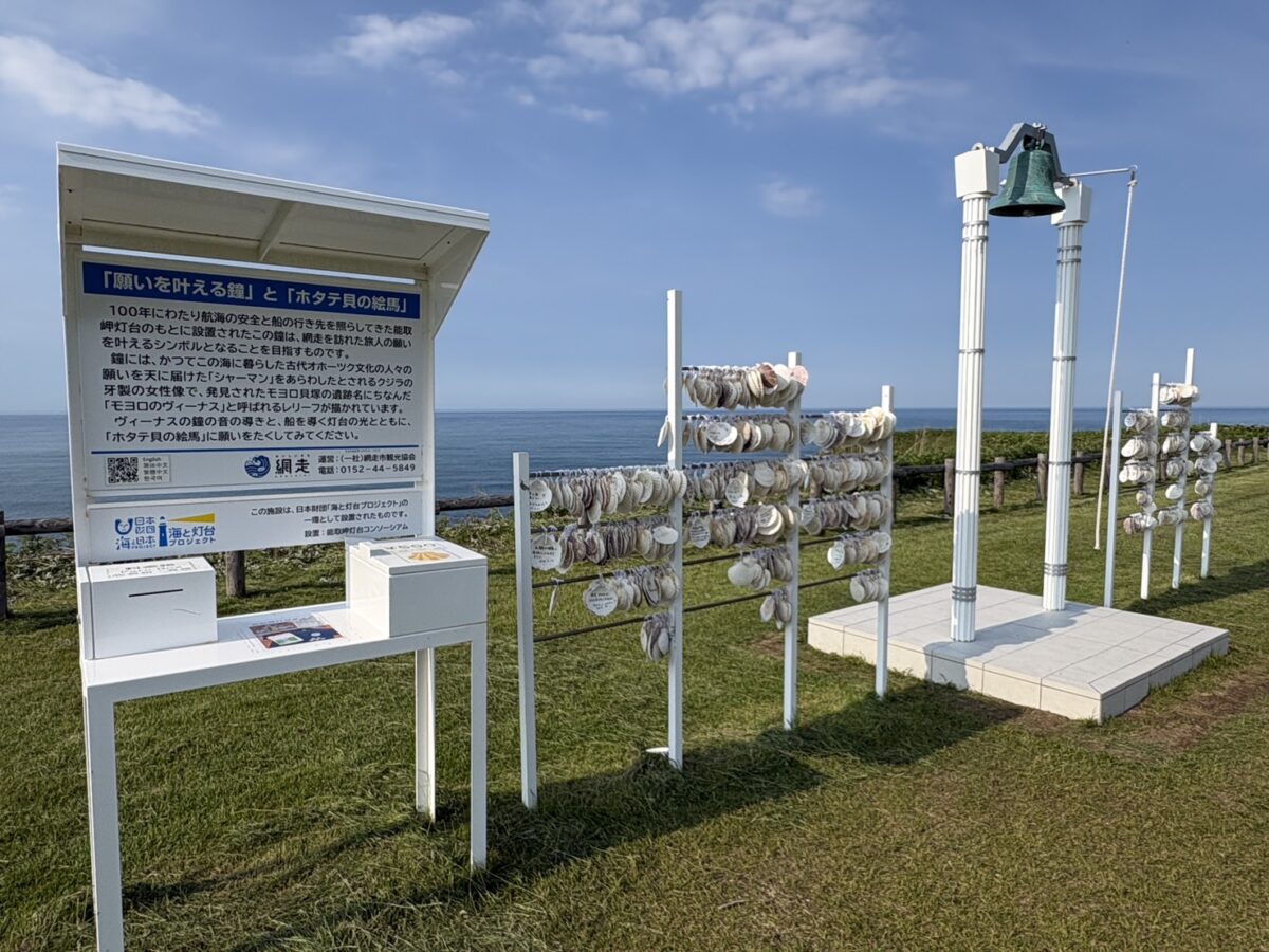 オホーツクの海を背景に佇む能取岬の「願いを叶える鐘」とホタテ貝の絵馬掛け
The "Wishing Bell" and scallop shell ema hanging racks overlooking the Okhotsk Sea at Cape Notoro