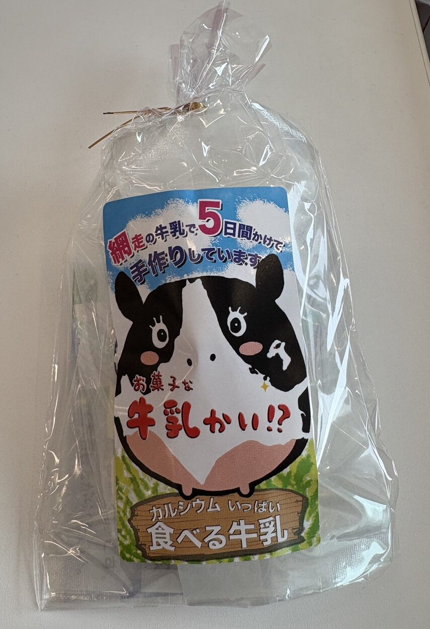 「お菓子な牛乳かい！？」の外袋パッケージ。牛の可愛いイラストと「網走の牛乳で5日間かけて手作りしています」の表記。
Front package of "Okashina Gyunyu-kai!?", a milk confectionery handcrafted over 5 days using local Abashiri milk.