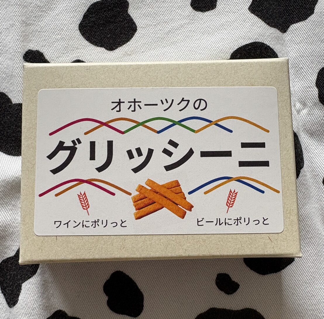 オホーツク産小麦を使用した「オホーツクのグリッシーニ」の箱パッケージ。ワインやビールのおつまみに最適な焼き菓子。
Box package of "Okhotsk Grissini", a crispy breadstick snack made with local wheat, perfect for pairing with wine or beer.