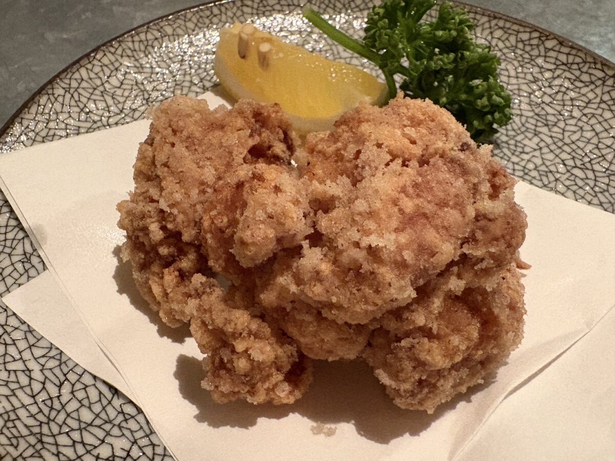 網走「屯屯(TONTON)」のサクサクジューシーな網走ザンギ(鶏のから揚げ)。カットレモン添え。 Crispy Abashiri-style Zangi (Japanese fried chicken) served with lemon at izakaya TONTON.