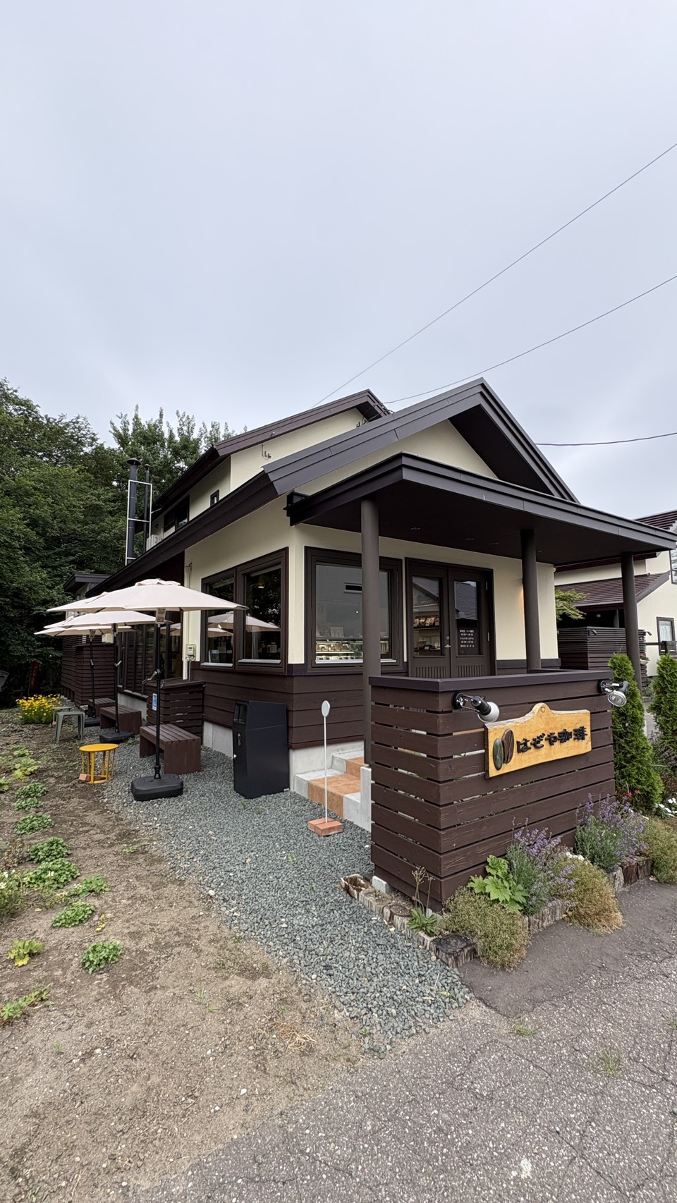 テラス席や「BENCH」の案内看板があり、屋外でコーヒーを楽しめる「はぜや珈琲」の敷地内
Outdoor seating area with a bench sign and parasol at Hazeya Coffee