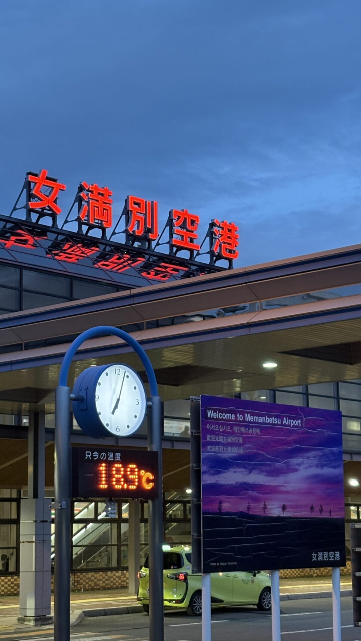 夜のとばりに赤く光る「女満別空港」の看板と、現在の気温が表示された時計塔
Illuminated sign and temperature display at Memanbetsu Airport entrance in the evening