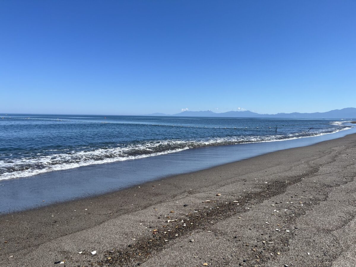 網走・濤沸湖周辺のオホーツク海沿岸。青い海と波打ち際、どこまでも続く海岸線の風景。
Scenic view of the Okhotsk Sea beach and coastline with gentle waves near Lake Tofutsu in Abashiri.