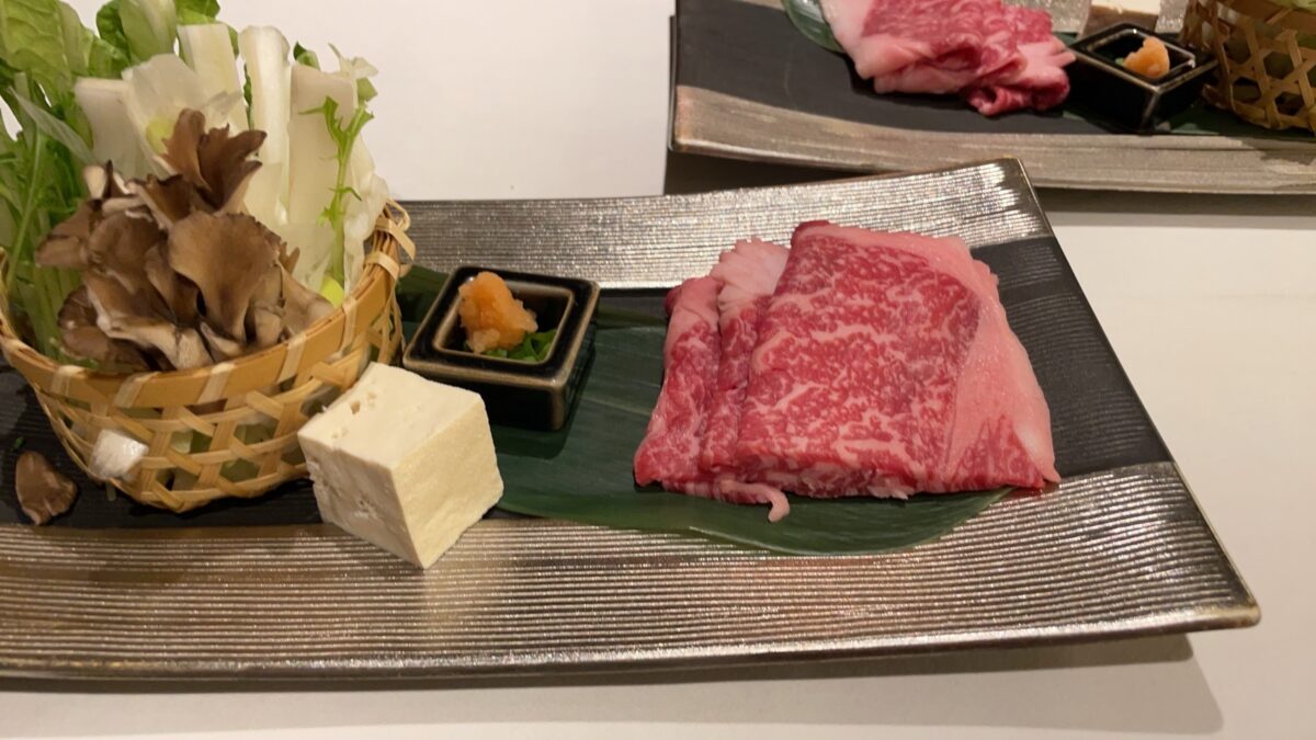 美しい霜降りの特選肉や新鮮な野菜、キノコを味わう会席料理の鍋御膳
Exquisite hot pot dish featuring premium marbled beef and fresh local vegetables for dinner